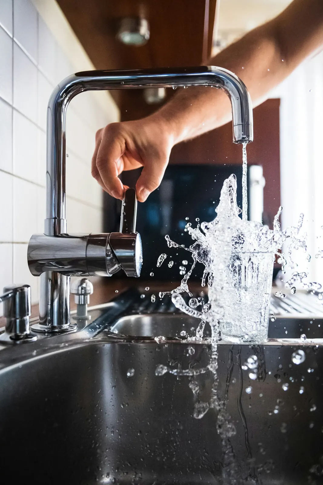 A hand turning on a faucet
