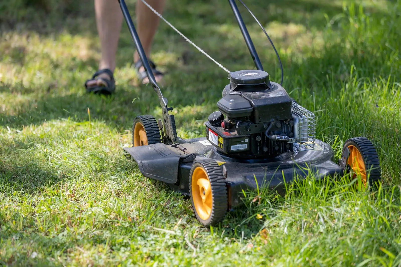 A person mowing grass with a lawn mower